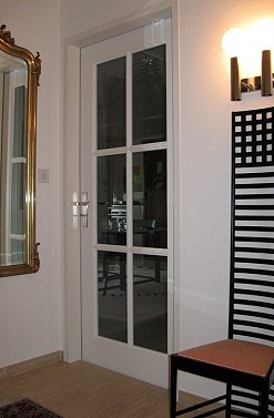 Eine Glastr zwischen Flur und Wohnzimmer in identischer Gestaltung wie die Tr zwischen Flur und Kche.